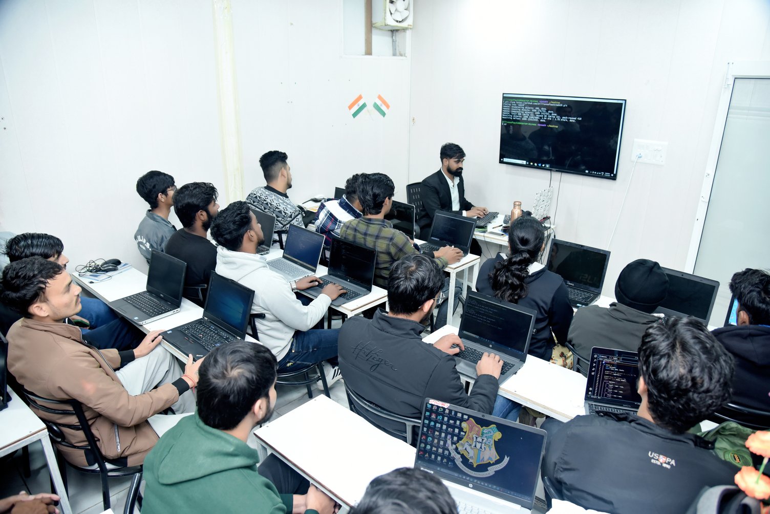 Students working on coding projects during a practical classroom training session.